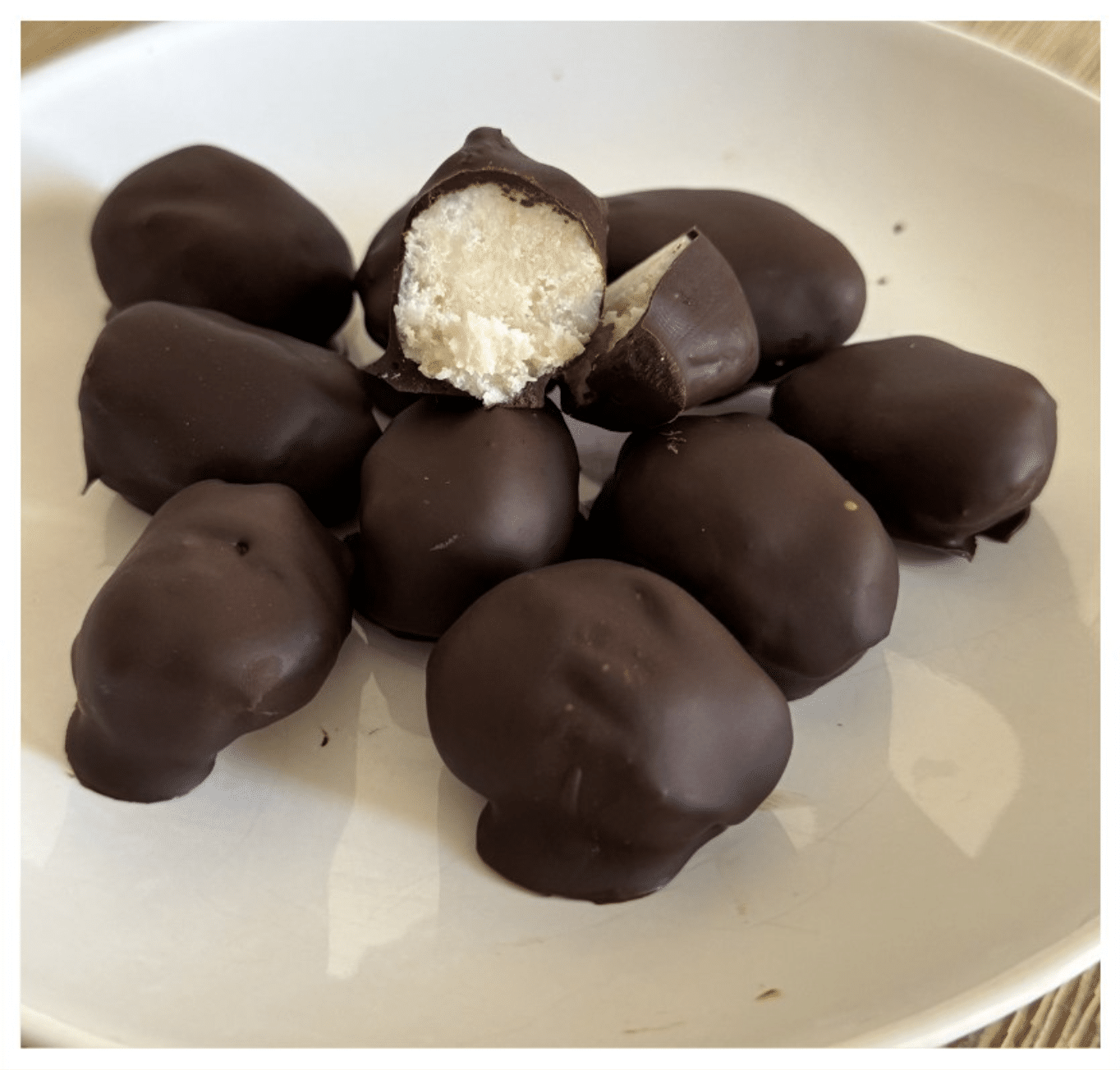 Diese Keto Bounty Bites sind der perfekte süße Keto Snack für zwischendurch: cremige Kokoscreme trifft auf knackige Schokolade.